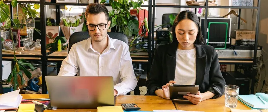 2 Pessoas trabalhando em escritório com notbook e um Ipad