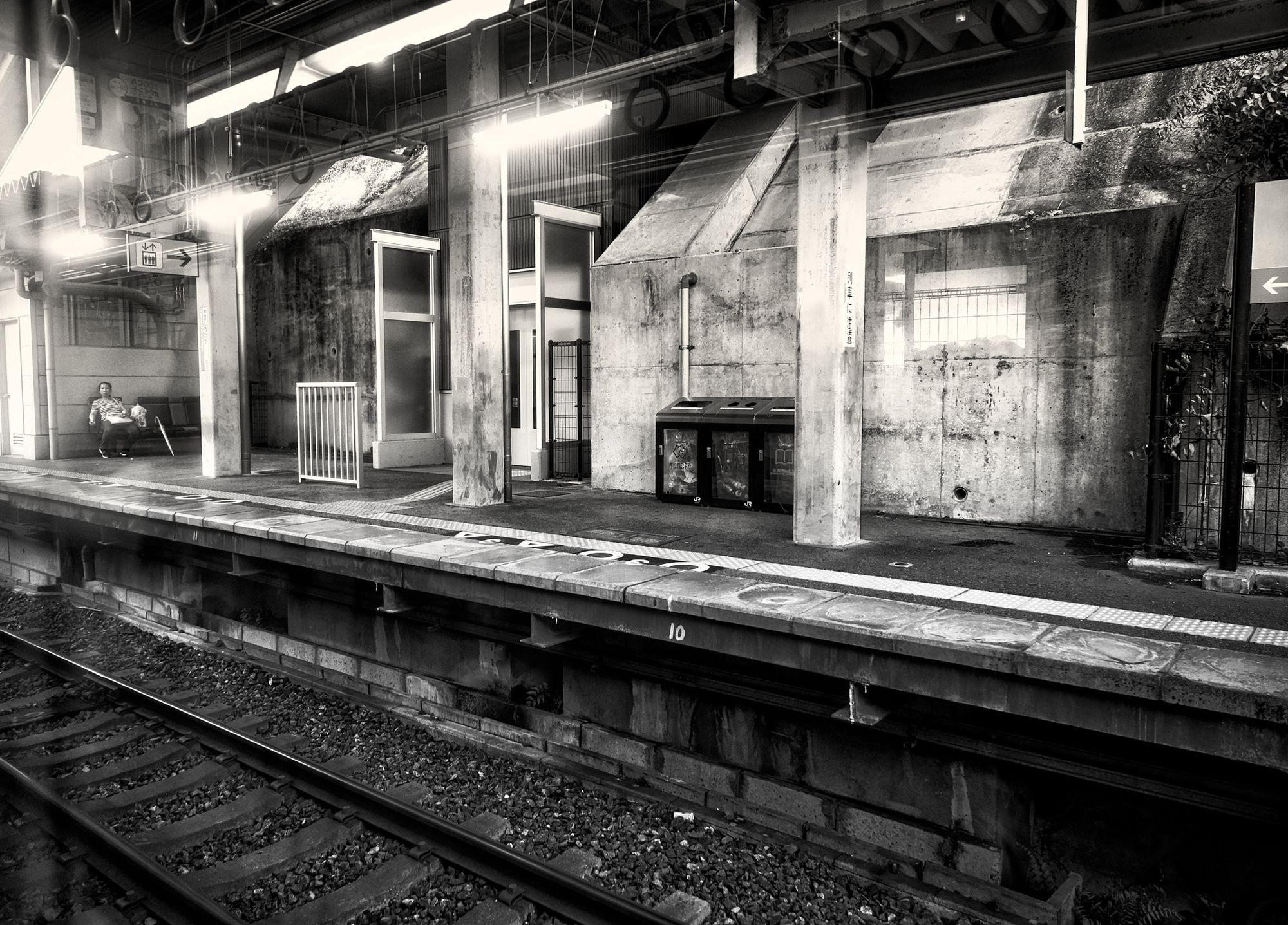 A lonely man sitting on a bench at a train station in Tokyo, Japan