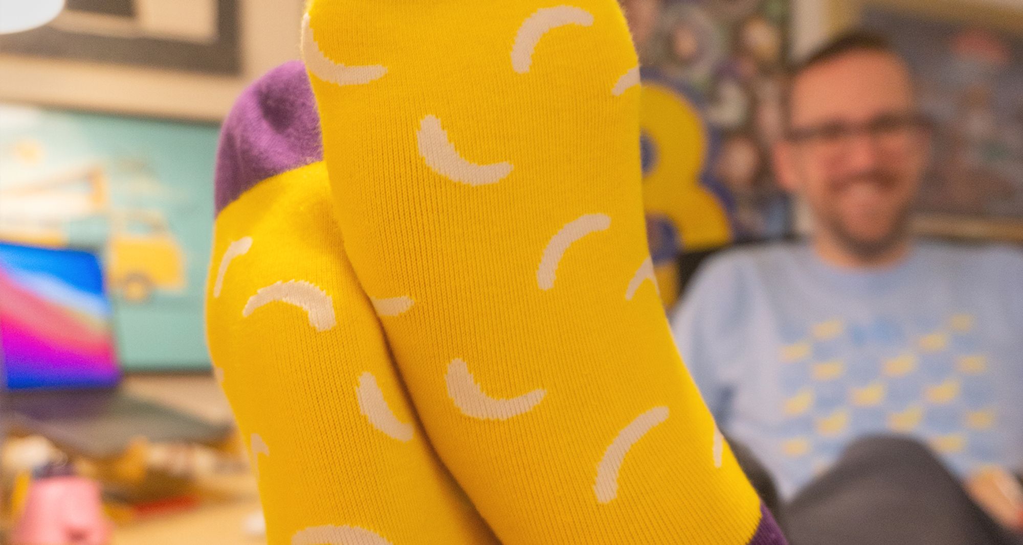 Photo of me with my feet up on the desk, showing off my banana patterned socks