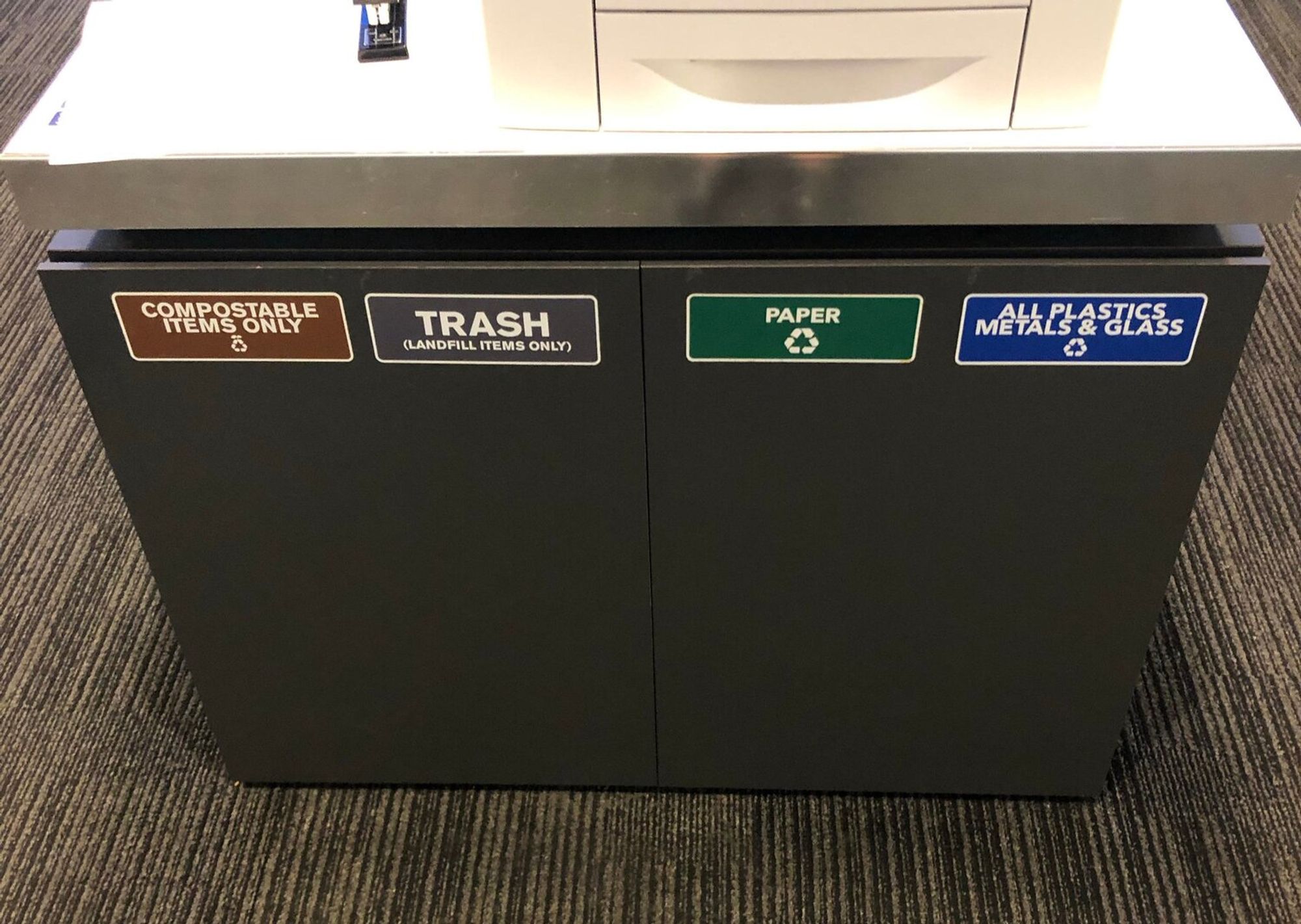 A typical waste station at a Bloomberg office. It includes compost, landfill, paper recycling and plastic recycling.
